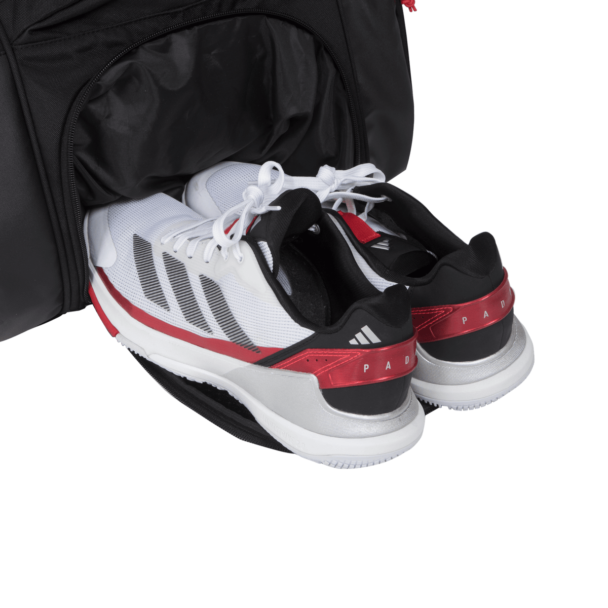 Witte sportschoenen in het schoenenvak van de zwarte Adidas Multigame 3.4 racketbag.