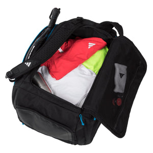 Geopende zwarte Adidas Protour 3.4 racketbag gevuld met sportkleding en handdoek.