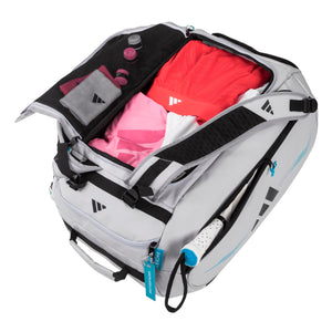 Geopende witte Adidas Protour 3.4 racketbag met roze en rode kleding erin.