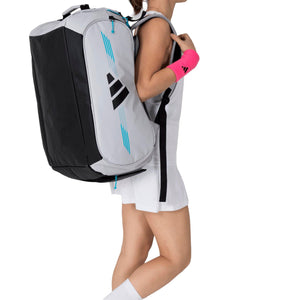 Speelster met de witte Adidas Protour 3.4 racketbag op de rug, van opzij gezien.