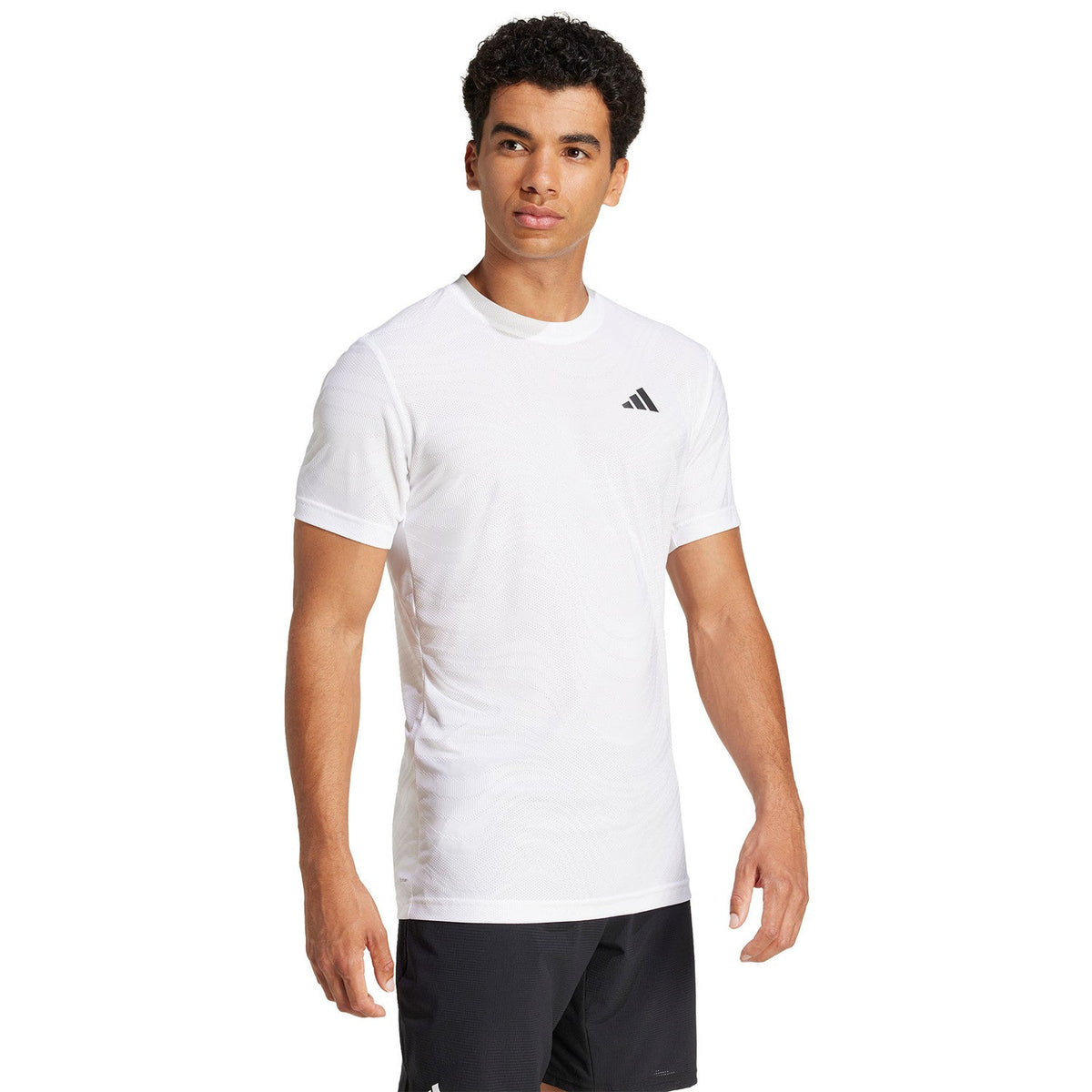 Vooraanzicht van model in het witte Adidas Freelift Pro T-shirt met zwarte short