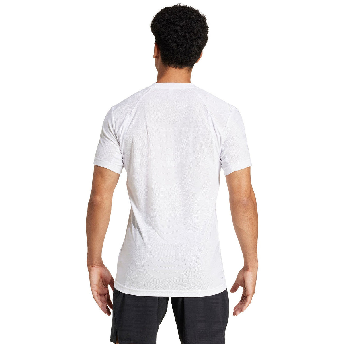 Achteraanzicht van model in het witte Adidas Freelift Pro T-shirt met korte mouwen