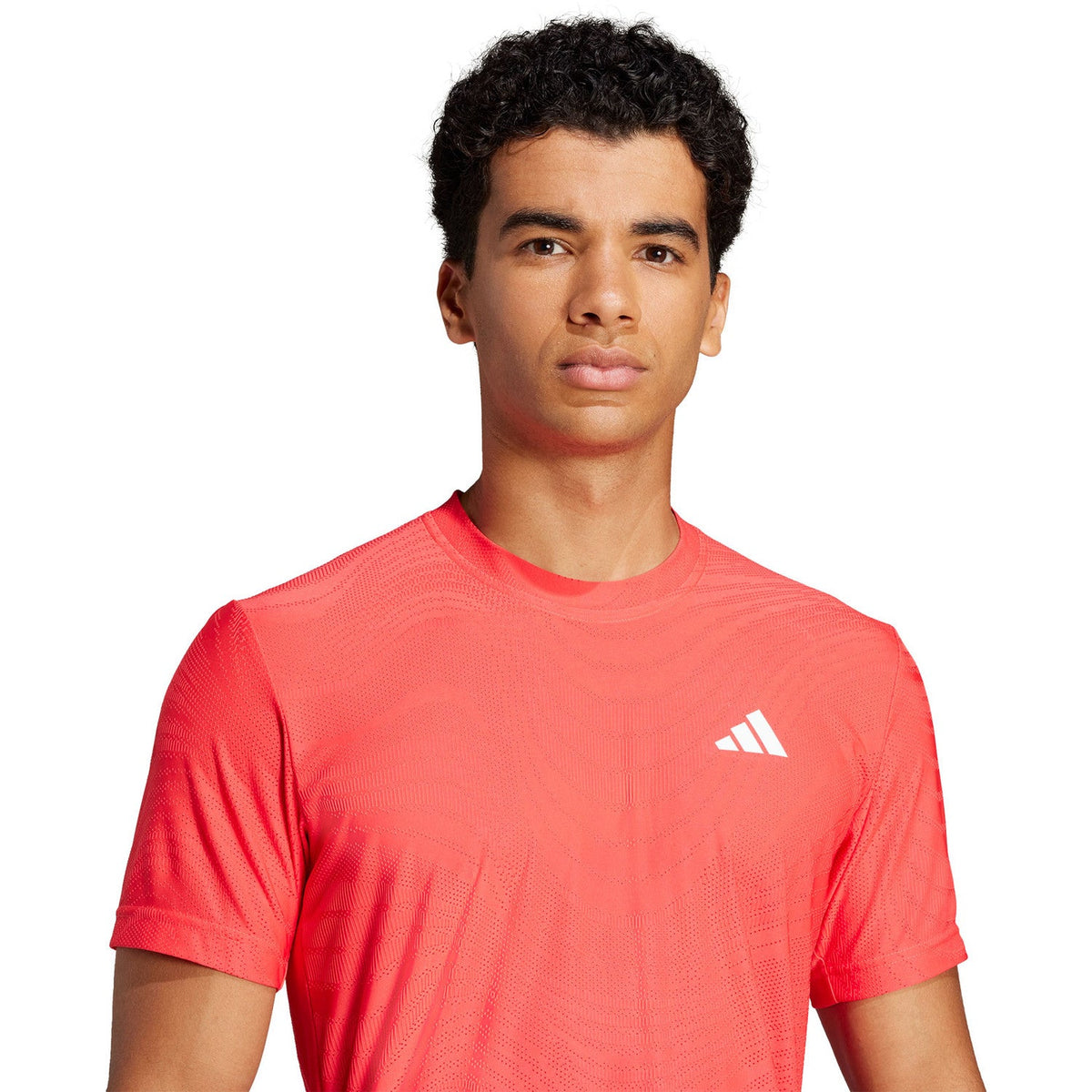 Model draagt het koraalrode Adidas Freelift Pro T-shirt, aanzicht van de borst