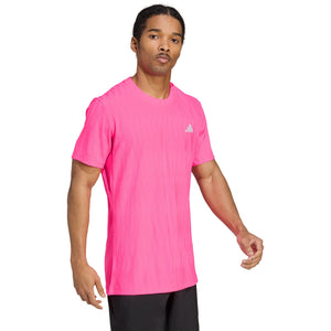 Model draagt het felroze Adidas Freelift T-shirt, halfaanzicht van opzij