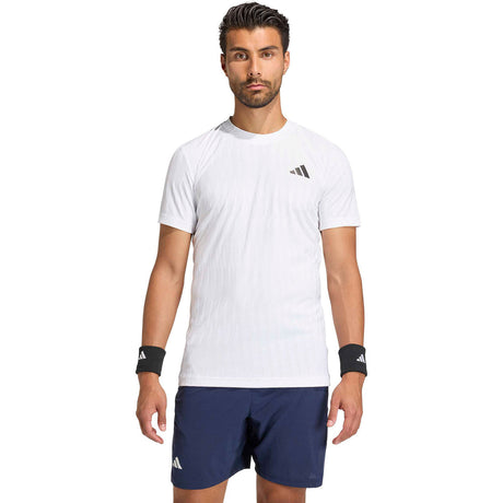 Model draagt het witte Adidas Freelift T-shirt met donkerblauwe short