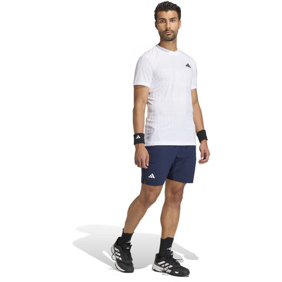 Model in wit Adidas Freelift T-shirt en donkerblauwe short, volledig aanzicht
