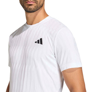 Close-up van het zwarte borstlogo op het witte Adidas Freelift T-shirt