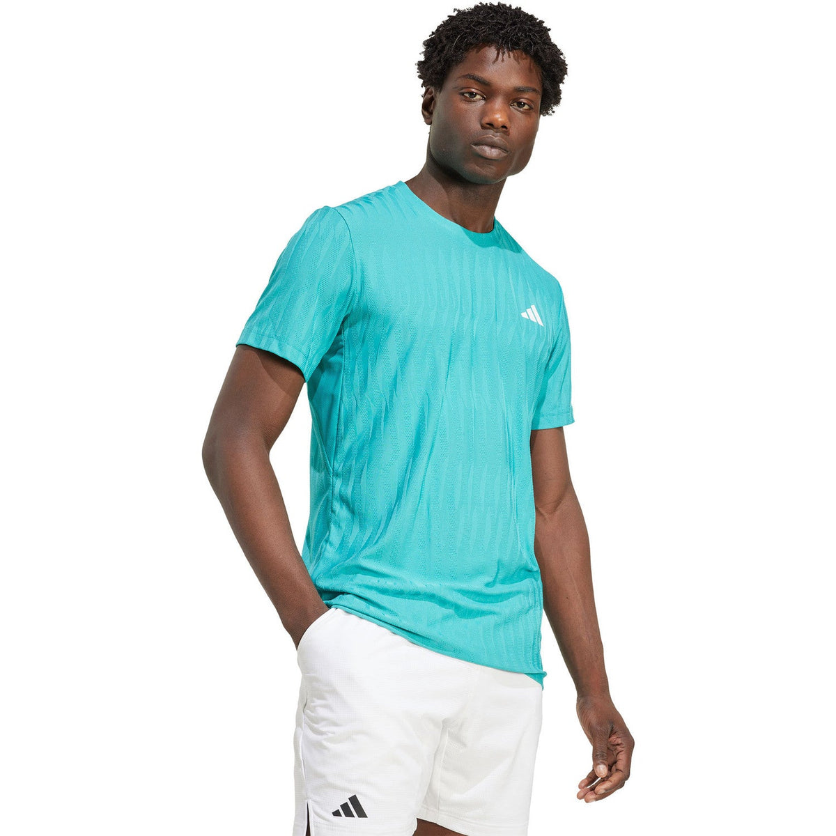 Model draagt het turquoise Adidas Freelift T-shirt, halfaanzicht van opzij
