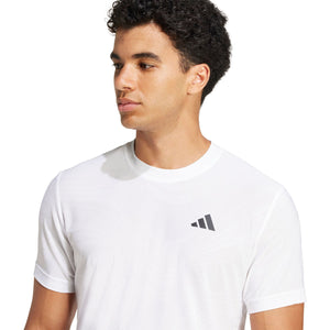 Model draagt het witte Adidas Freelift T-shirt, halfaanzicht van opzij