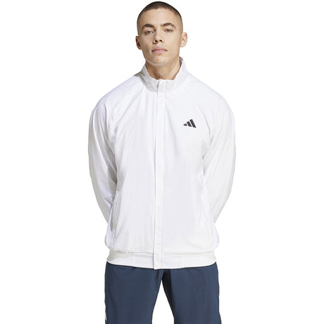 Vooraanzicht van model in het witte Adidas Walk On jack met opstaande kraag en rits