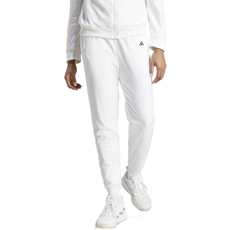 Model draagt de witte Adidas Walk On dames trainingsbroek met witte sneakers, vooraanzicht