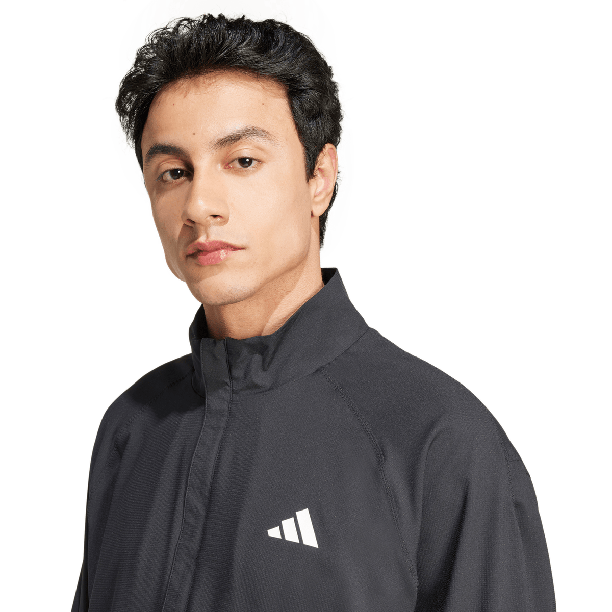 Close-up van het zwarte Adidas Walk On jack met wit logo op de borst