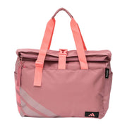 Vooraanzicht van de roze Adidas Weekend Bag 2026 met koraalroze draagbanden.