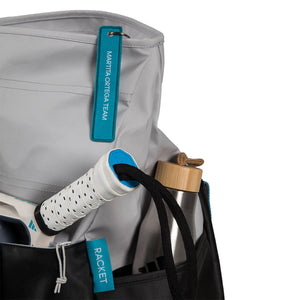 Detail van het zijvak van de Adidas Weekendbag 3.4 met racket en turquoise label.