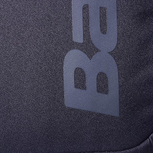 Close-up van het grijze Babolat logo op het zwarte weefsel van de Court Lite rugzak.
