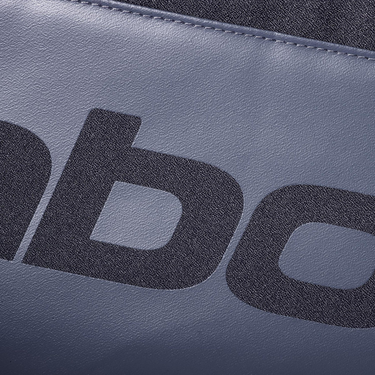 Close-up van het grijze Babolat logo op het gladde paneel van de Court S