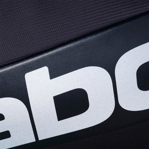 Close-up van het witte Babolat logo op donkere stof van de rackettas
