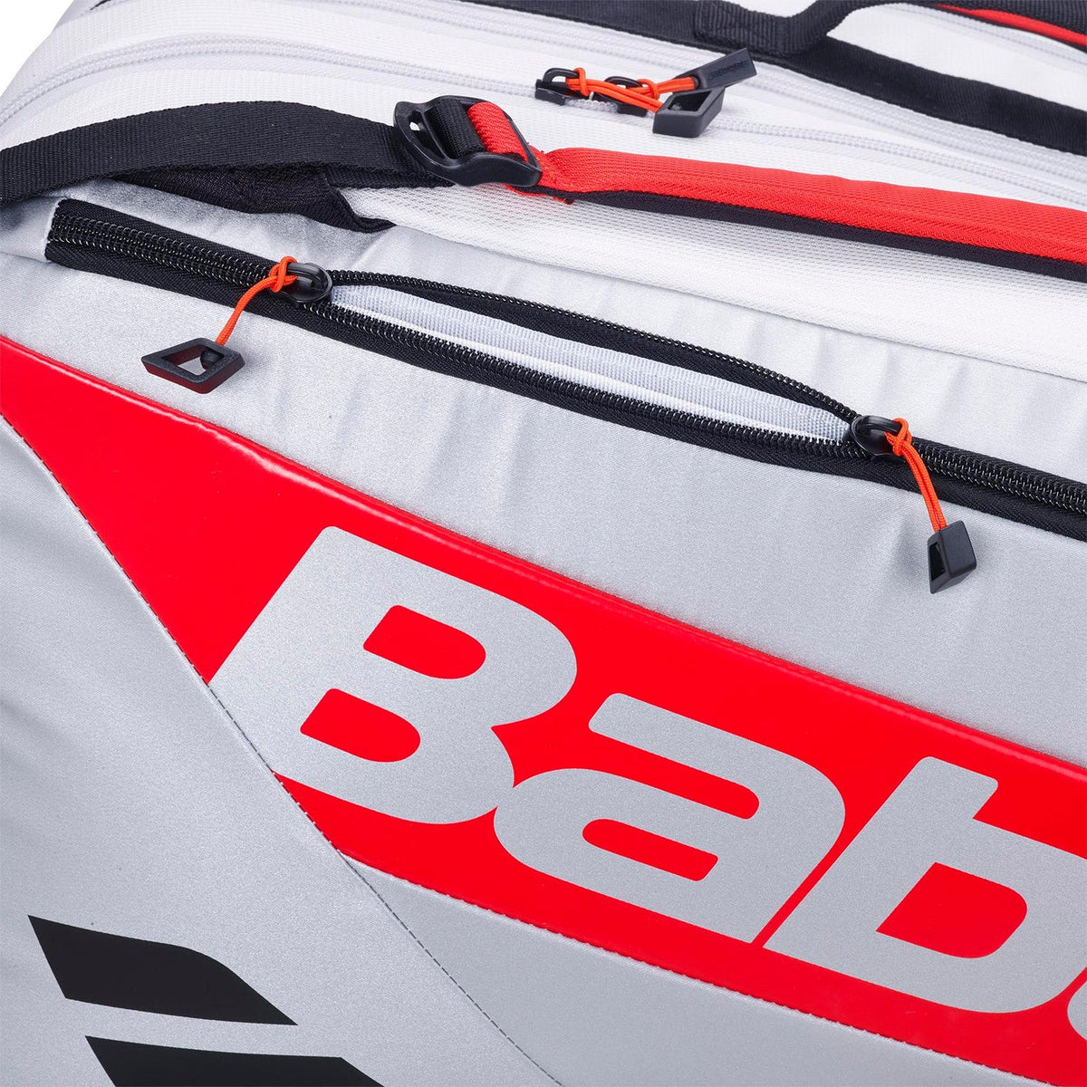 Detail van de rode rits en zwarte gesp op de witte Babolat padeltas