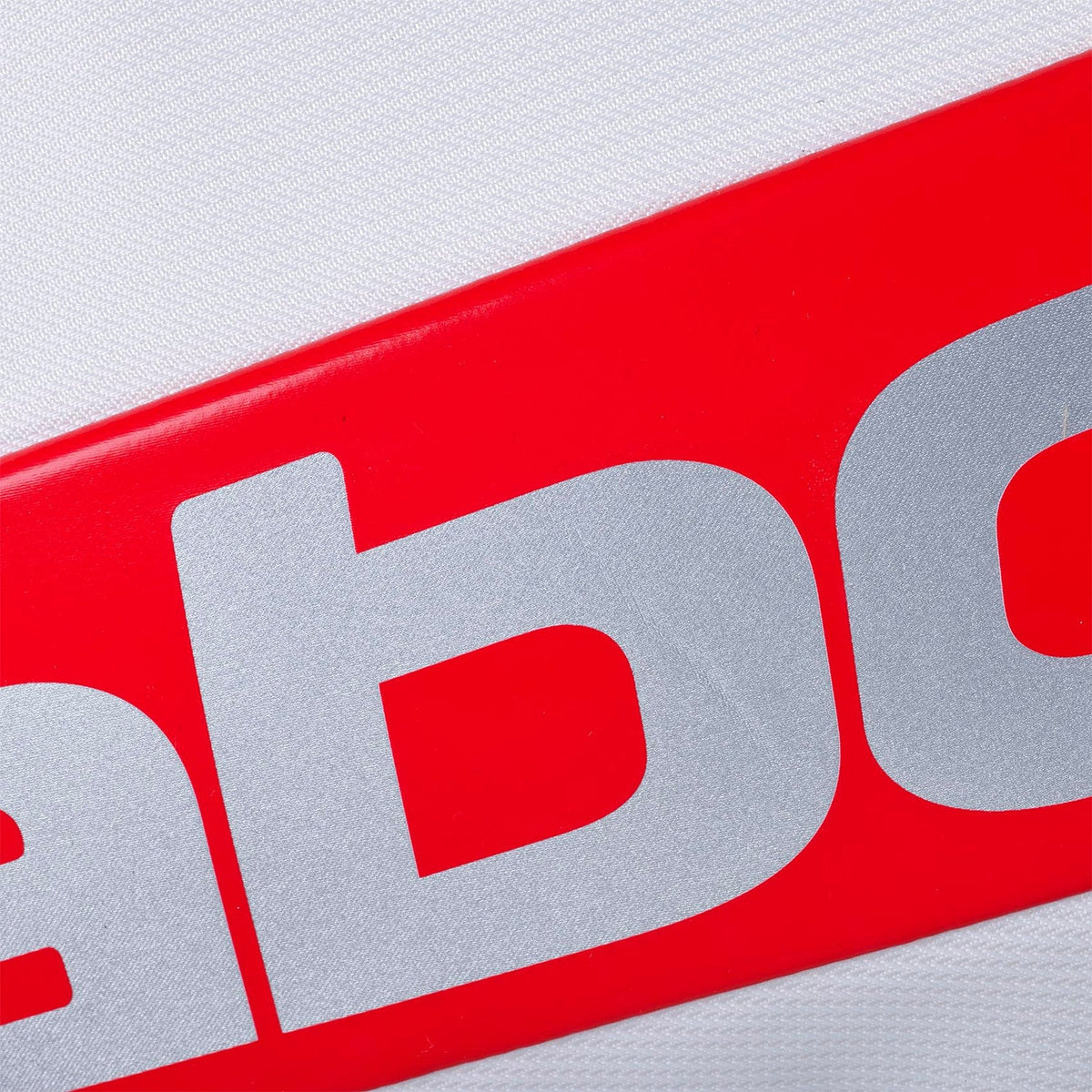 Close-up van het rode Babolat logo op het witte paneel van de rackettas