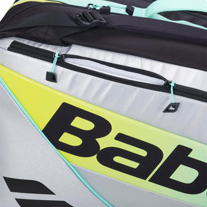 Detail van de gele Babolat opdruk op het witte paneel met mintgroene rits