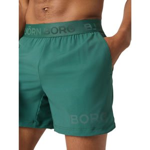 Zijaanzicht van de groene Bjorn Borg 6 inch short met hand in de steekzak