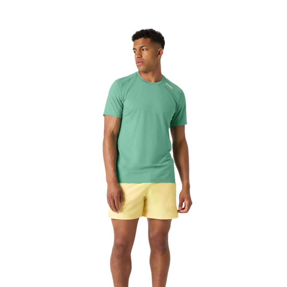 Model draagt de gele Bjorn Borg 6 inch short met groen T-shirt