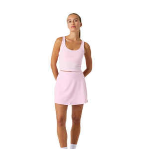 Model draagt de lichtroze Bjorn Borg Ace cropped tanktop met bijpassende rok, volledig vooraanzicht