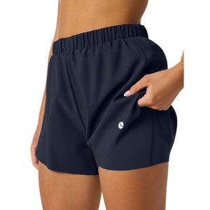 Zijaanzicht van de donkerblauwe Ace 2-in-1 short met hand in de steekzak