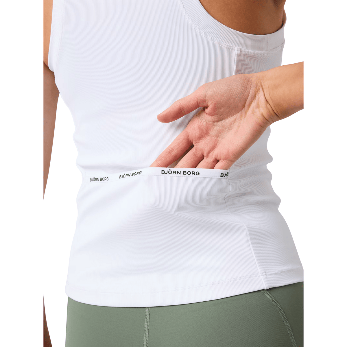 Model stopt een bal in de rugzak van de witte Bjorn Borg Ace tanktop