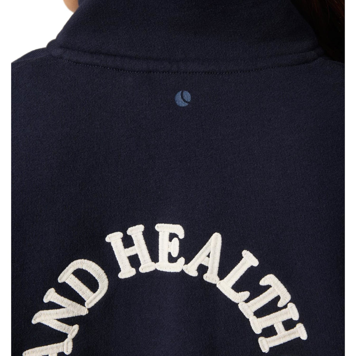 Close-up van de geweven stof met witte AND HEALTH letters op de donkerblauwe Bjorn Borg trui