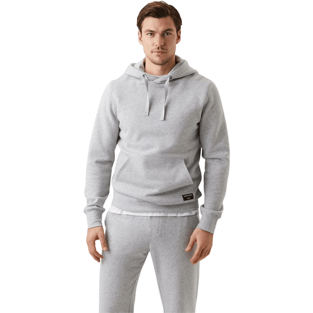 Herenmodel draagt de lichtgrijze Bjorn Borg Centre Hoodie met bijpassende joggingbroek
