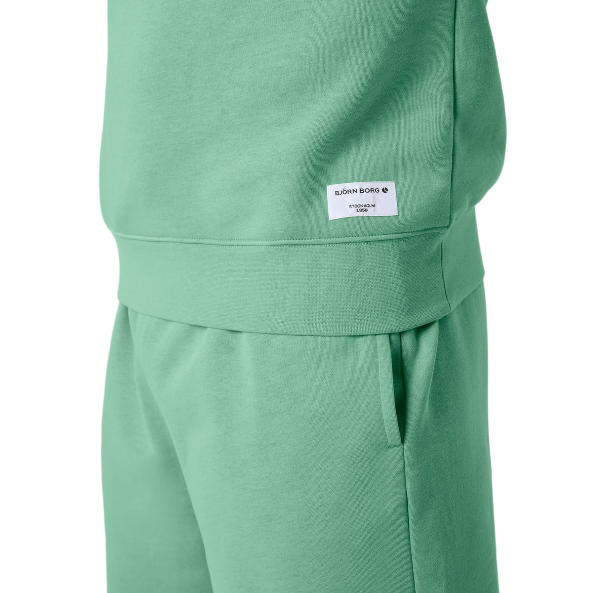 Detail van de zoom met wit label op het mintgroene Bjorn Borg Centre Sweatshirt en short
