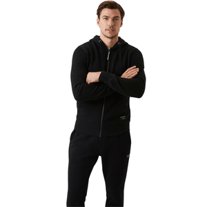 Herenmodel met gekruiste armen in de zwarte Bjorn Borg Centre Zip Hoodie en zwarte broek