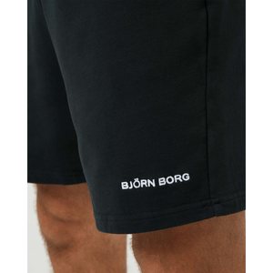 Detail van het witte Bjorn Borg-logo op de pijp van de zwarte sweatshort