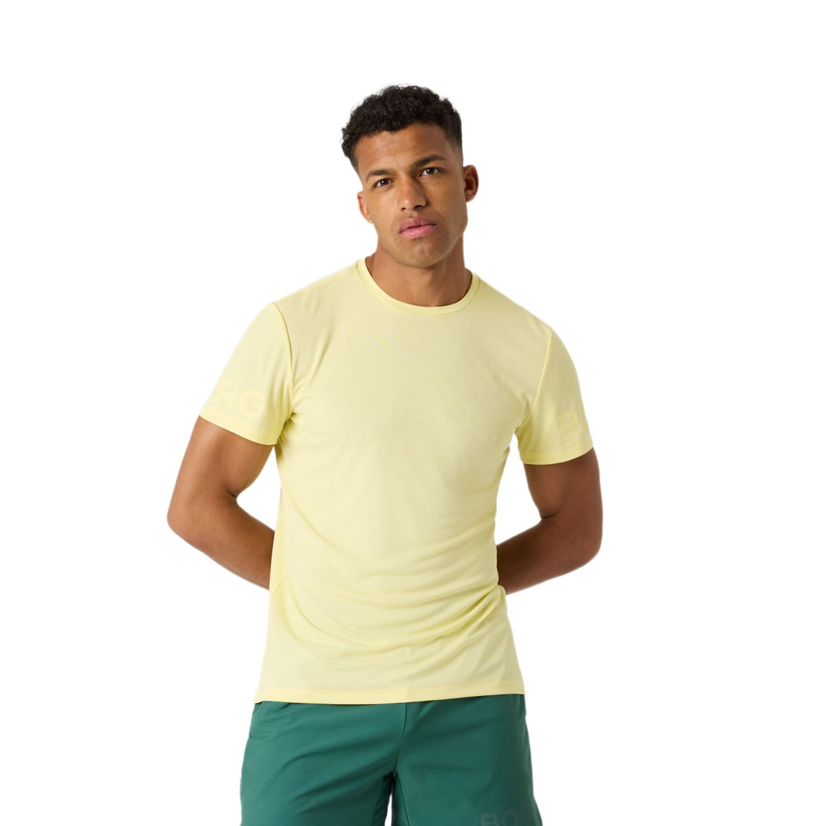 Model draagt het Bjorn Borg Light T-shirt voor heren in geel met groene short