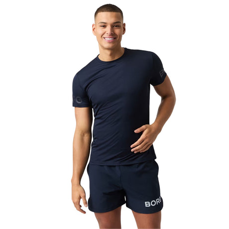 Model draagt het Bjorn Borg Light T-shirt voor heren in donkerblauw met short