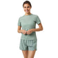 Damesmodel draagt het saliegroene Bjorn Borg Light W T-Shirt met groene korte broek