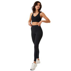 Damesmodel draagt de zwarte Bjorn Borg Logo Tights met zwarte sportbeha