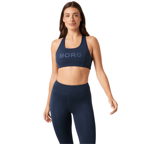 Damesmodel draagt de donkerblauwe Bjorn Borg Mid Support Sports Bra met legging