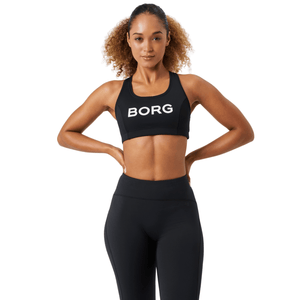 Damesmodel draagt de zwarte Bjorn Borg Mid Support Sports Bra met zwarte legging