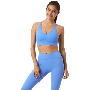 Damesmodel draagt de blauwe Bjorn Borg Mid V Support Sports Bra met blauwe legging