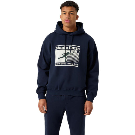 Herenmodel draagt de donkerblauwe Bjorn Borg Oversized Hoodie met Monte Carlo print