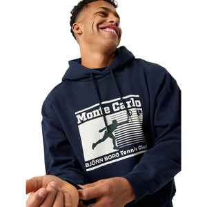 Close-up van de witte Monte Carlo Tennis Club opdruk op de donkerblauwe hoodie