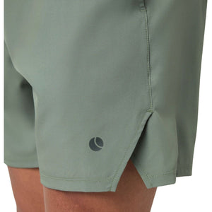 Close-up van de zijsplit en het logo op de saliegroene Short Ace Racquet sportshort