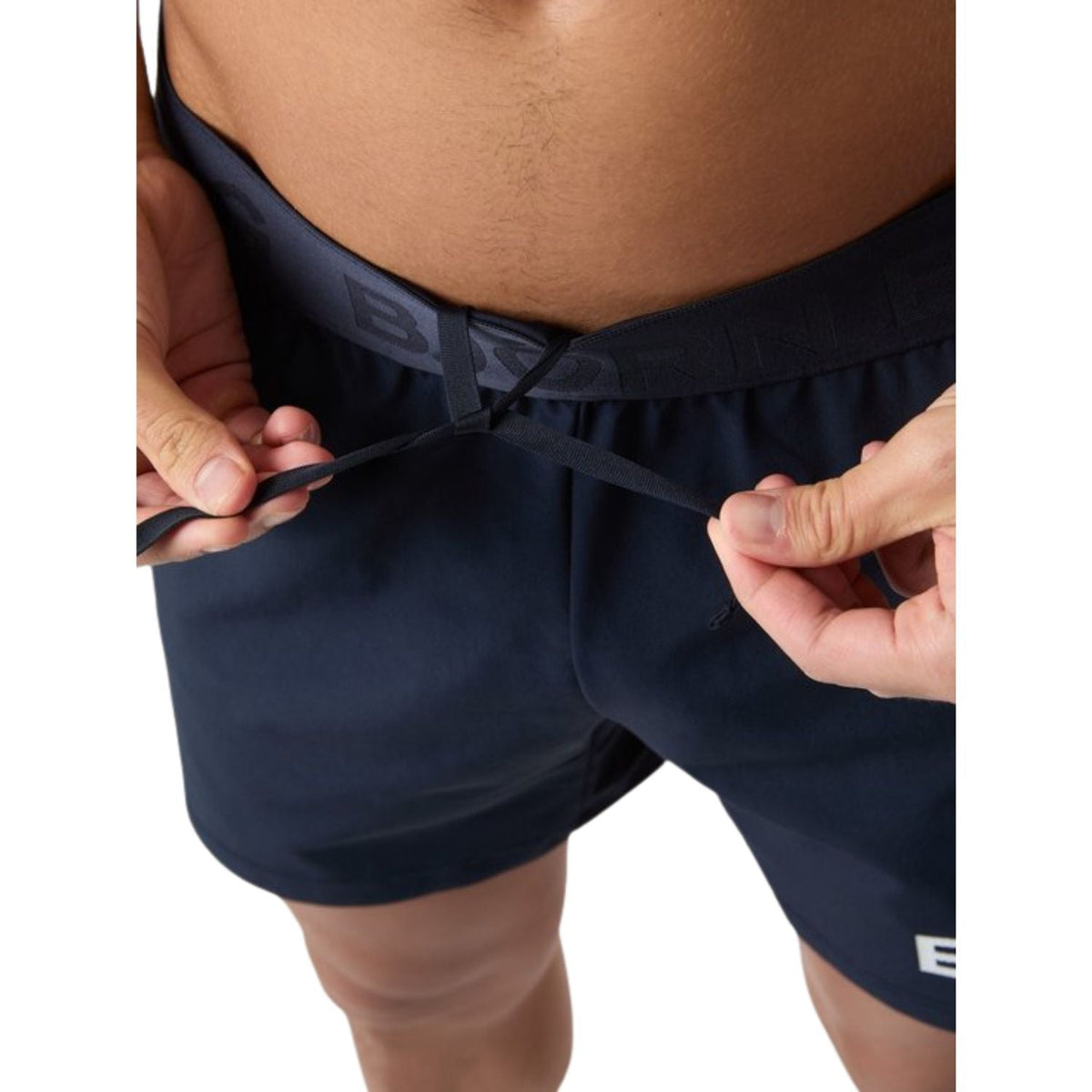 Model trekt de marineblauwe Bjorn Borg Short Shorts aan, detail van de taille