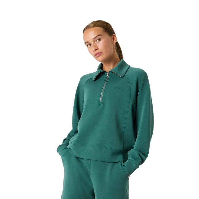 Model draagt de groene Bjorn Borg Studio Soft Halfzip sweater met bijpassende broek