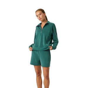Model ten voeten uit in de groene Bjorn Borg Studio Soft Halfzip sweater met short