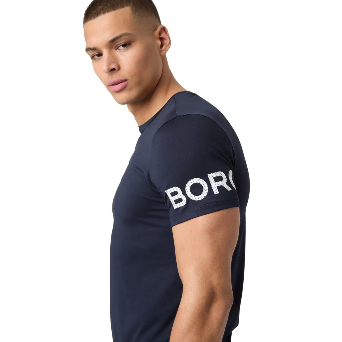 Detail van de witte BORG-print op de mouw van het marineblauwe T-shirt