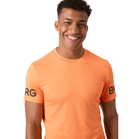 Model draagt het oranje Bjorn Borg T-shirt met BORG-print, halfaanzicht