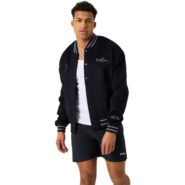 Model draagt het donkerblauwe Bjorn Borg Varsity Jacket met witte streepboorden